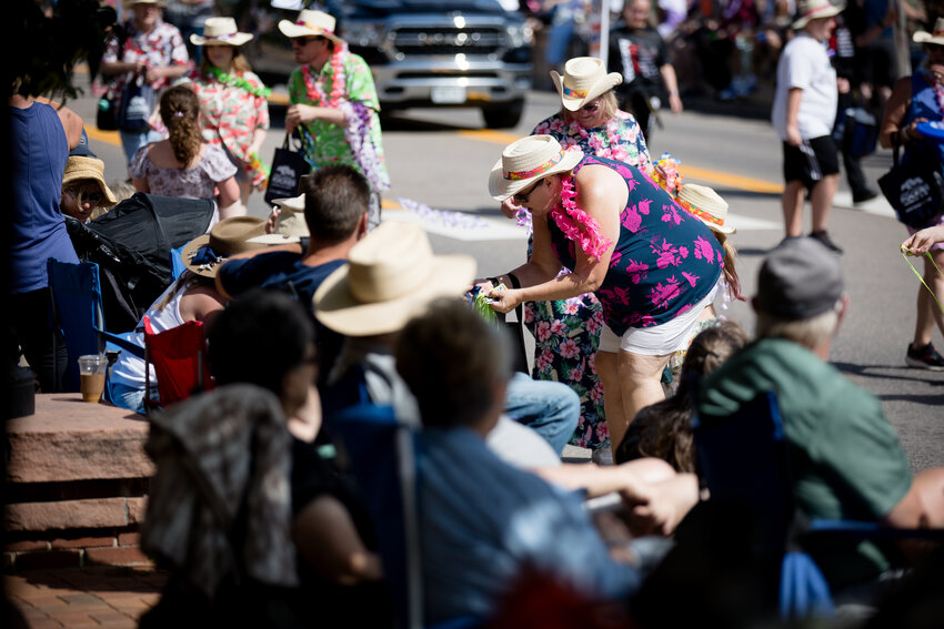 People from Credit Union of the Rockies hand out leis as they make their way down the parade route Saturday morning.